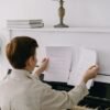 Niño sentado ante un piano con la partitura bien iluminada y el banco ajustado