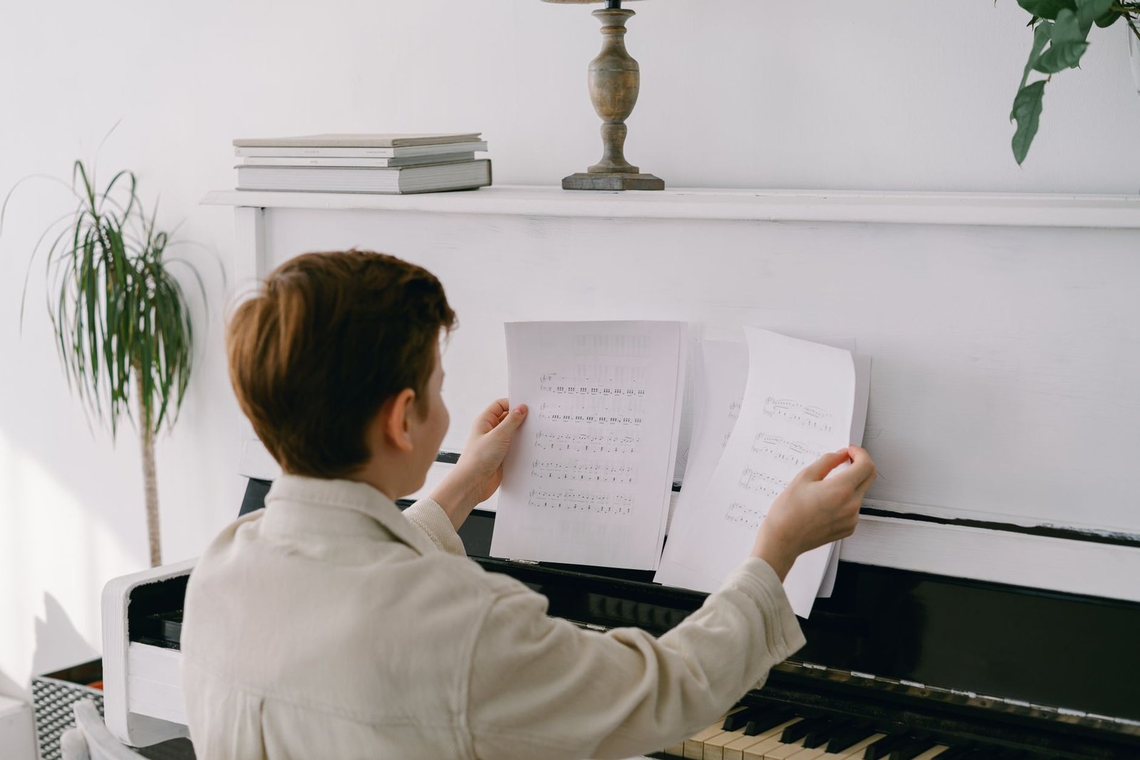 Niño sentado ante un piano con la partitura bien iluminada y el banco ajustado
